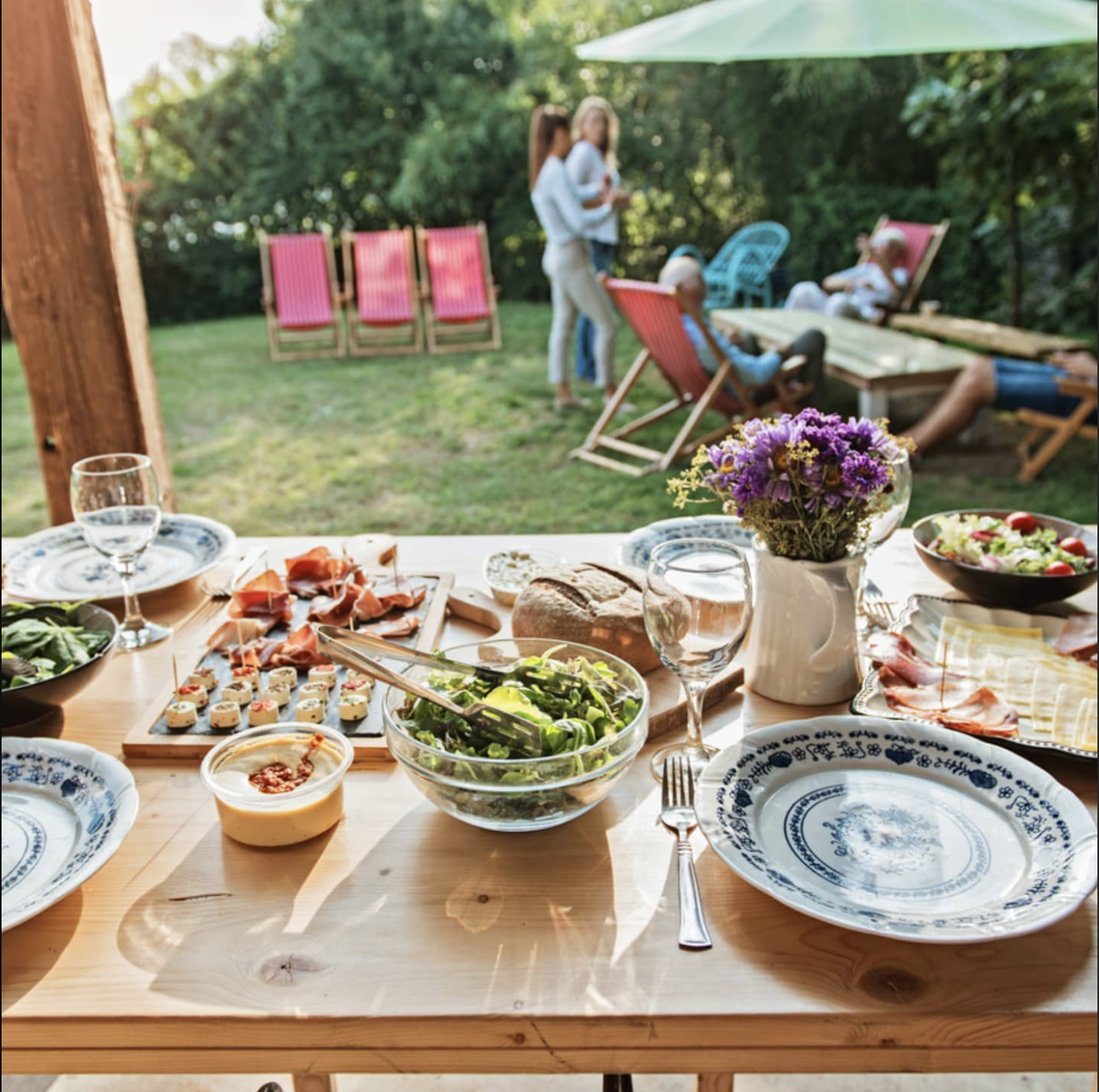 A beautifully set outdoor dining table with guests enjoying a private chef experience